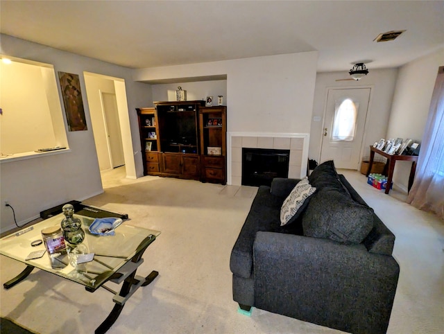 carpeted living room with a tile fireplace