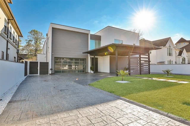 view of front of house featuring a carport, a garage, and a front lawn