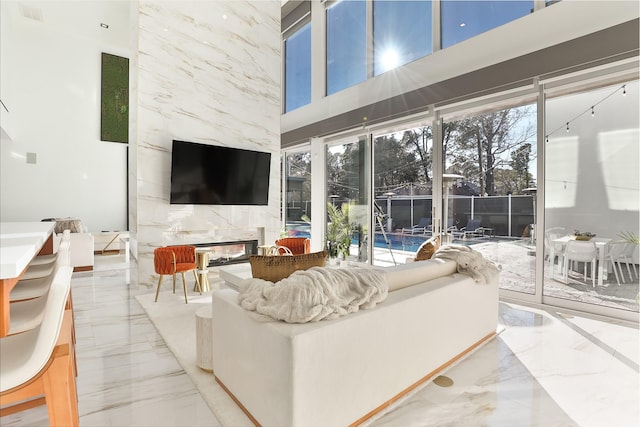 living room featuring a towering ceiling and a fireplace