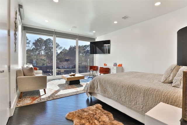 bedroom with hardwood / wood-style flooring and a wall of windows