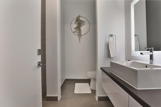 bathroom with tile patterned flooring, vanity, and toilet