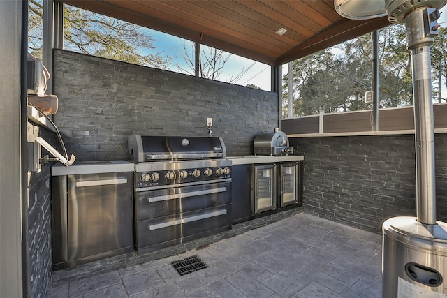 view of patio / terrace with an outdoor kitchen, a grill, and beverage cooler