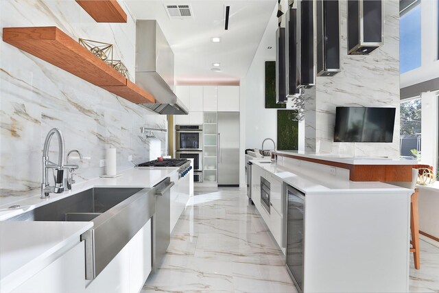 kitchen with sink, extractor fan, white cabinetry, appliances with stainless steel finishes, and beverage cooler