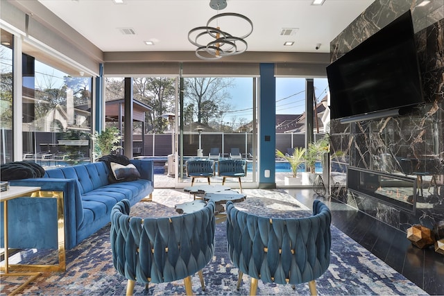 living room featuring a high end fireplace, a chandelier, and wood-type flooring