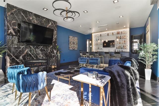 living room featuring bar, hardwood / wood-style flooring, and a premium fireplace