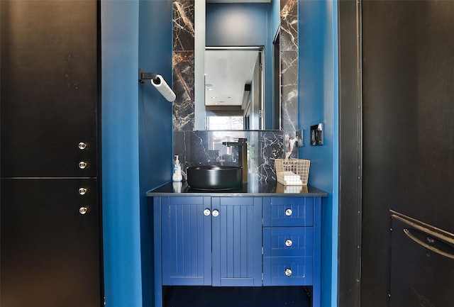 bar featuring tasteful backsplash, blue cabinets, and sink