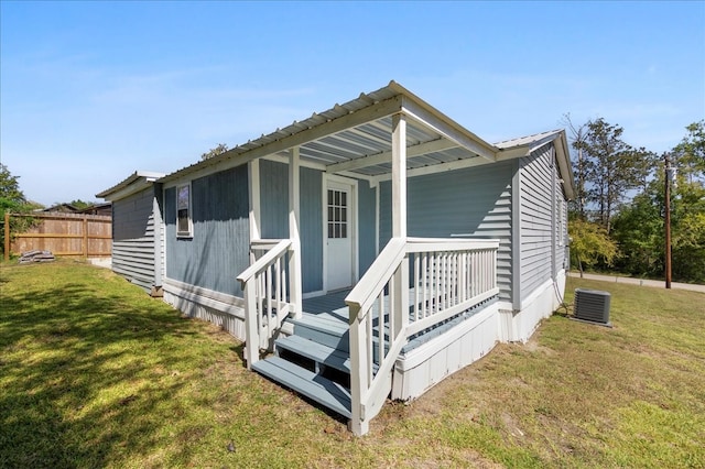 exterior space with central AC unit and a lawn