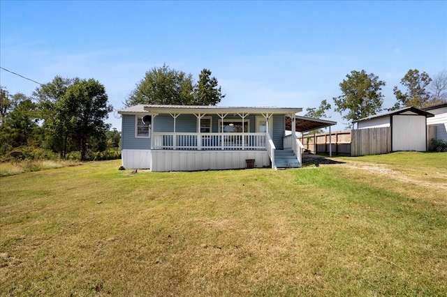 view of front of property featuring covered porch, a storage unit, and a front lawn