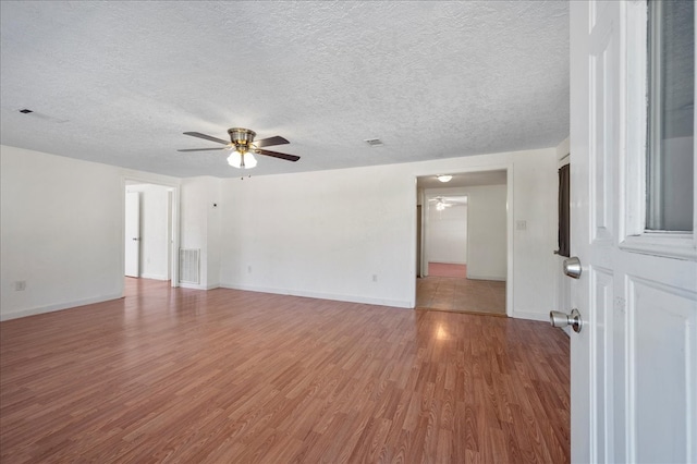 unfurnished room with a textured ceiling, hardwood / wood-style flooring, and ceiling fan