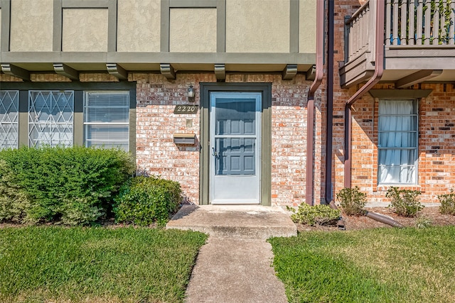 view of exterior entry featuring a balcony