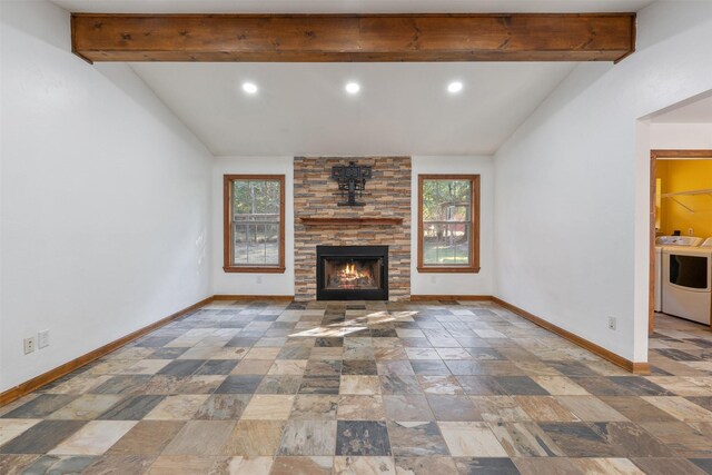 unfurnished living room featuring lofted ceiling with beams, a fireplace, and washer / clothes dryer