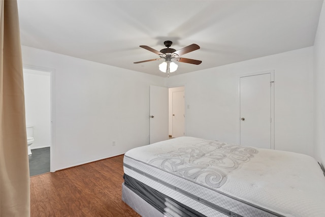 bedroom featuring connected bathroom, ceiling fan, a closet, and dark hardwood / wood-style floors