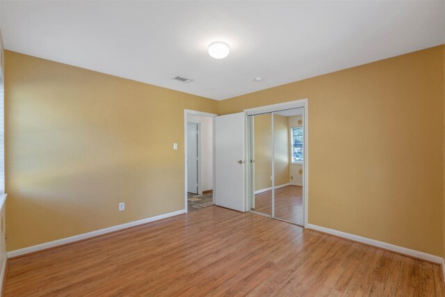 unfurnished bedroom featuring a closet and light wood-type flooring