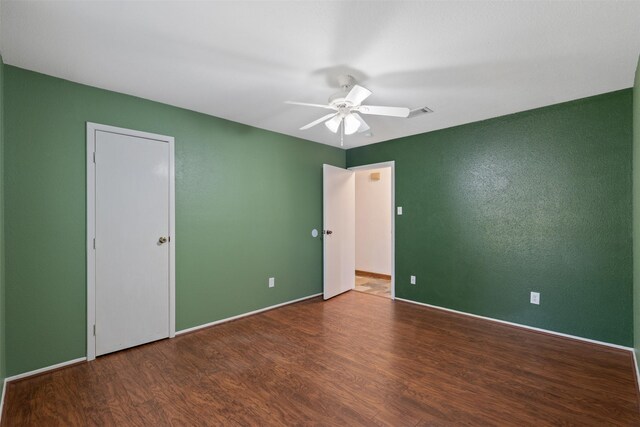 spare room with ceiling fan and dark hardwood / wood-style flooring