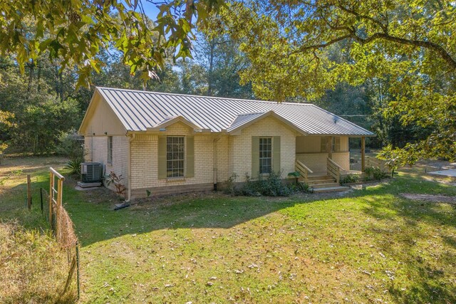 view of front of property with cooling unit and a front lawn