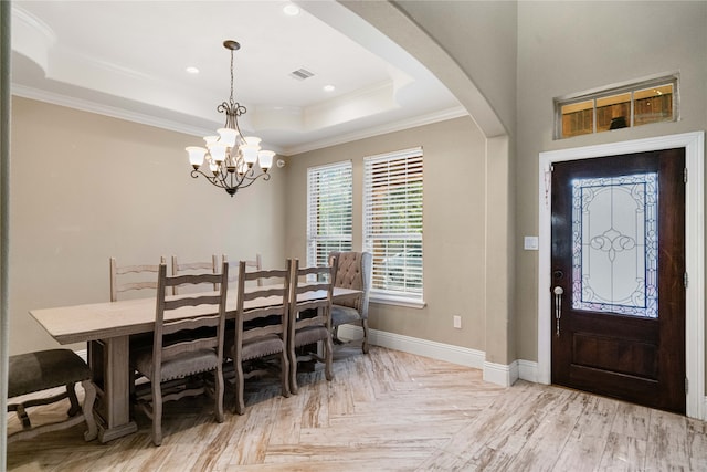 dining area with light parquet floors, ornamental molding, a tray ceiling, and a chandelier