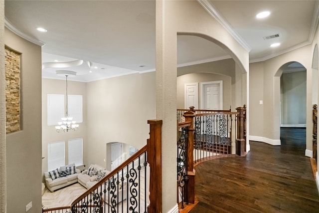 hallway featuring crown molding, a notable chandelier, and wood-type flooring