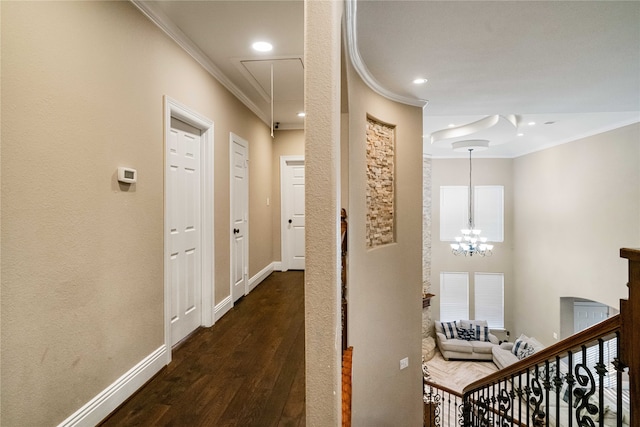 corridor featuring dark wood-type flooring, crown molding, and a notable chandelier