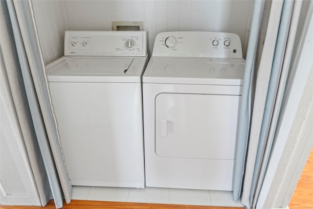 clothes washing area with light tile patterned floors and separate washer and dryer