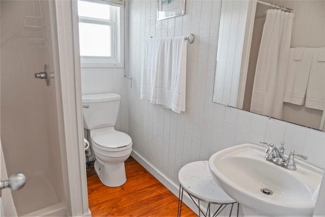 bathroom with toilet, curtained shower, hardwood / wood-style flooring, and sink