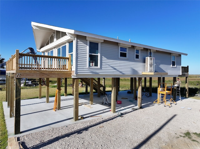 rear view of property with a wooden deck and a patio area