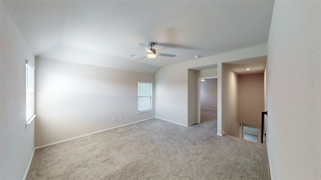 carpeted empty room featuring ceiling fan, a healthy amount of sunlight, and vaulted ceiling