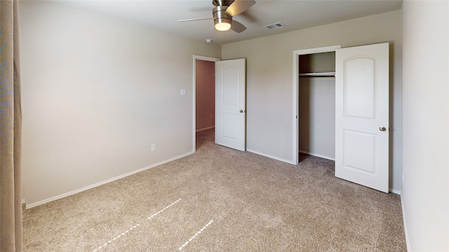 unfurnished bedroom with a closet, light colored carpet, and ceiling fan