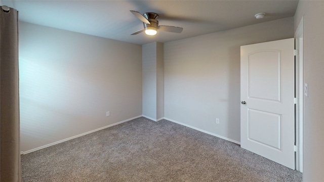 carpeted spare room featuring ceiling fan