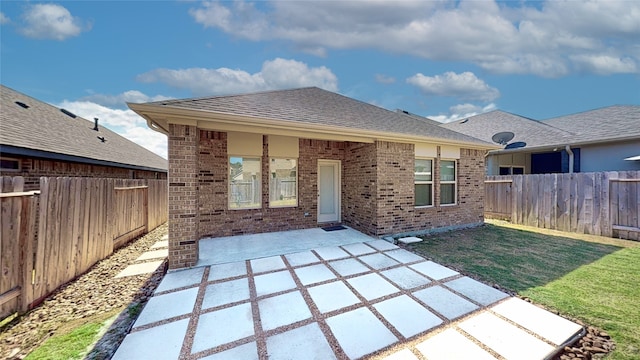 rear view of house with a yard and a patio area