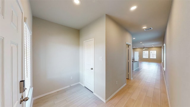 corridor with light hardwood / wood-style floors