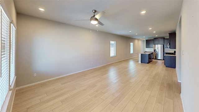 unfurnished living room featuring light wood-type flooring and ceiling fan