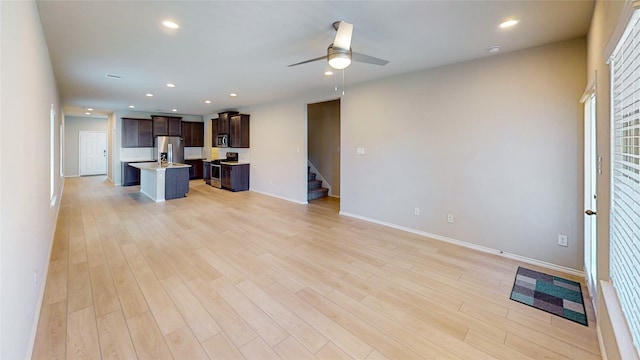 unfurnished living room featuring ceiling fan and light wood-type flooring