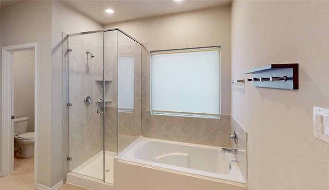 bathroom featuring toilet, plus walk in shower, and tile patterned flooring