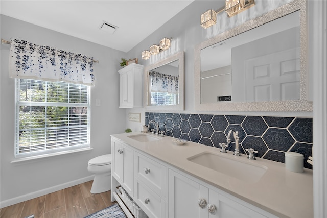 bathroom featuring vanity, toilet, wood-type flooring, and backsplash