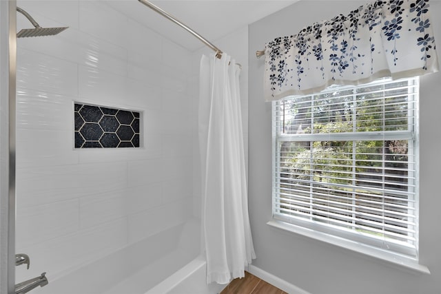 bathroom featuring a healthy amount of sunlight, shower / bath combo, and hardwood / wood-style flooring