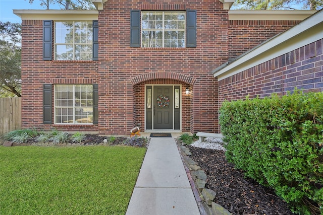 view of exterior entry with a lawn