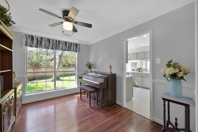 miscellaneous room with dark wood-type flooring, ceiling fan, and ornamental molding