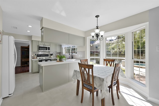 dining space featuring sink, a chandelier, and light hardwood / wood-style floors