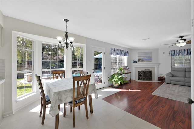 dining room featuring light hardwood / wood-style floors and ceiling fan with notable chandelier