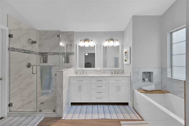 bathroom featuring vanity, hardwood / wood-style flooring, tile walls, and separate shower and tub