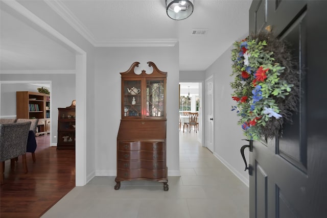 hallway with crown molding, hardwood / wood-style flooring, and a notable chandelier