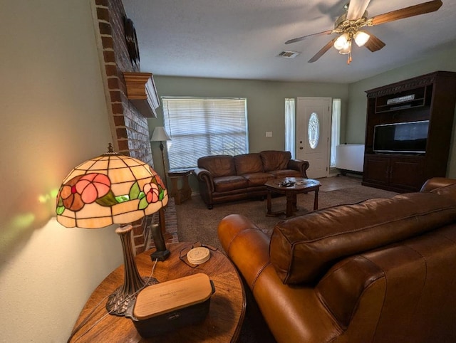 living room featuring ceiling fan, carpet, and a brick fireplace