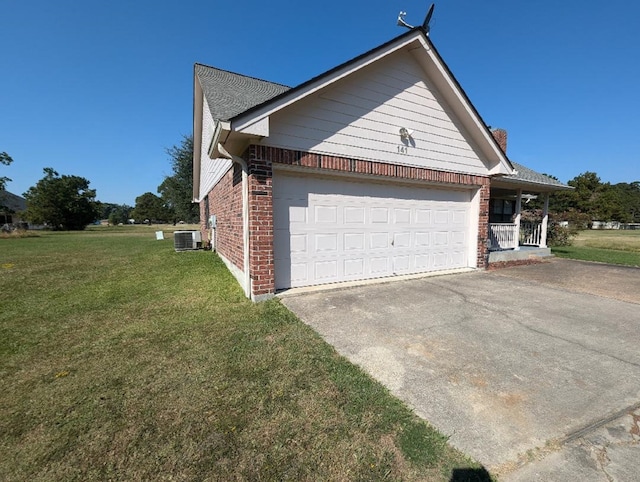 view of side of property featuring central air condition unit, a yard, and a garage