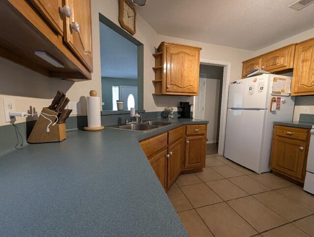 kitchen featuring sink, white appliances, and light tile patterned floors