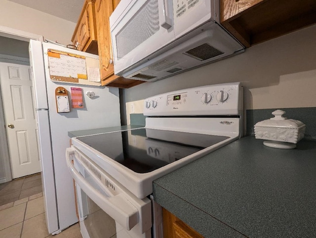 kitchen with light tile patterned floors and white appliances