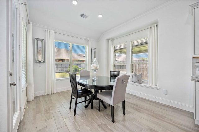 dining area with ornamental molding, visible vents, light wood-style flooring, and baseboards