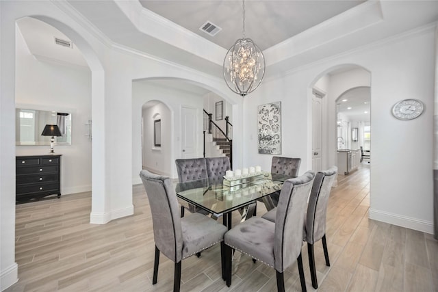 dining room with arched walkways, a raised ceiling, and visible vents