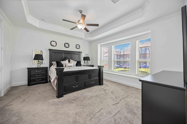 bedroom featuring a raised ceiling, light carpet, and baseboards