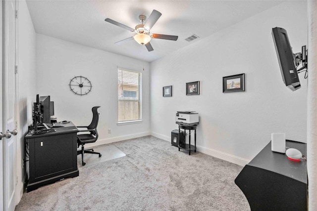 office area featuring a ceiling fan, light carpet, visible vents, and baseboards