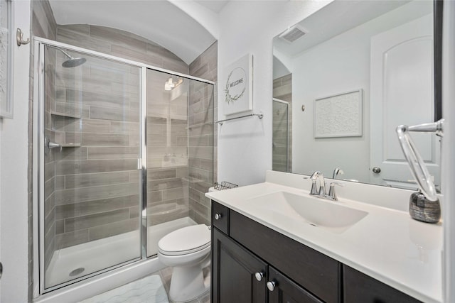 bathroom featuring a stall shower, visible vents, vanity, and toilet